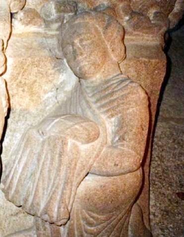 A servant carrying a stack of empanadas, carved in 12th-century Santiago de Compostela.